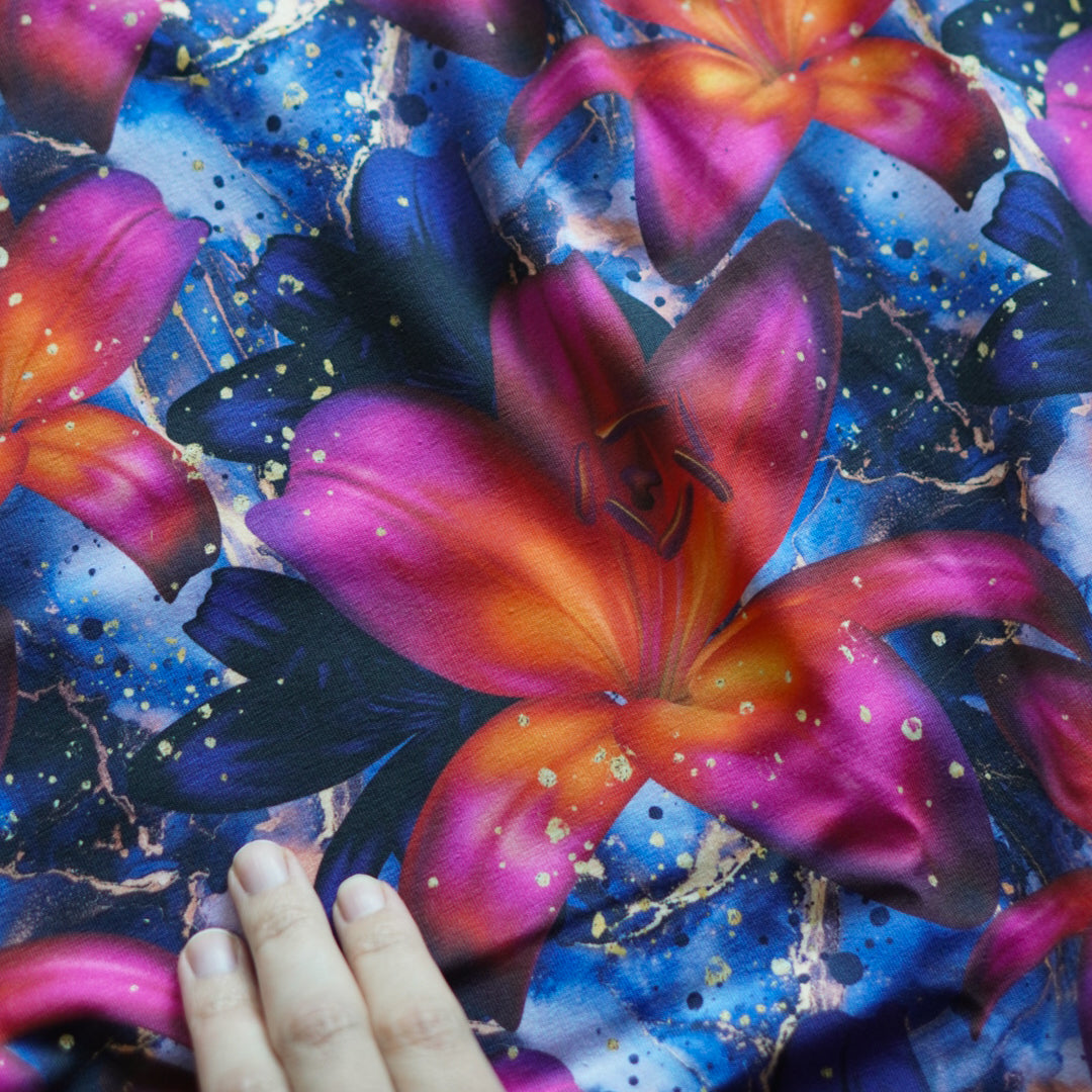 Damenstoff mit Blumen, orange/pinke Lilien auf blauem Hintergrund Handvergleich