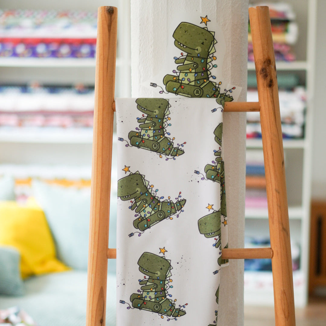 Kinderstoff mit weihnachtlichem Roboter als Tannenbaum verkleideter T-Rex von Katzengold Design mit Bügelbild