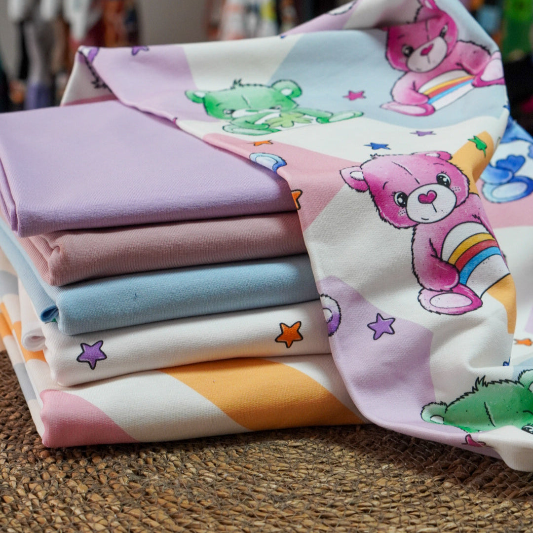 Kinderstoff Meterware mit süßes Bärchen voller Glück mit verschiedenen Symbolen von Katzengold Design als Kombistapel