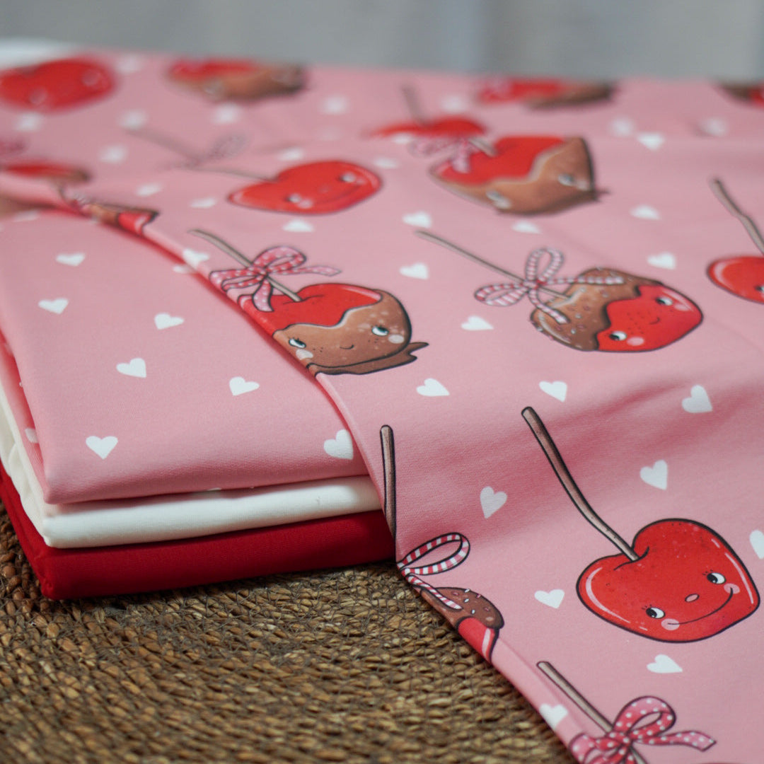 Kandierte Äpfel mit Gesichtern und Herzchen auf rosa von Katzengold Design