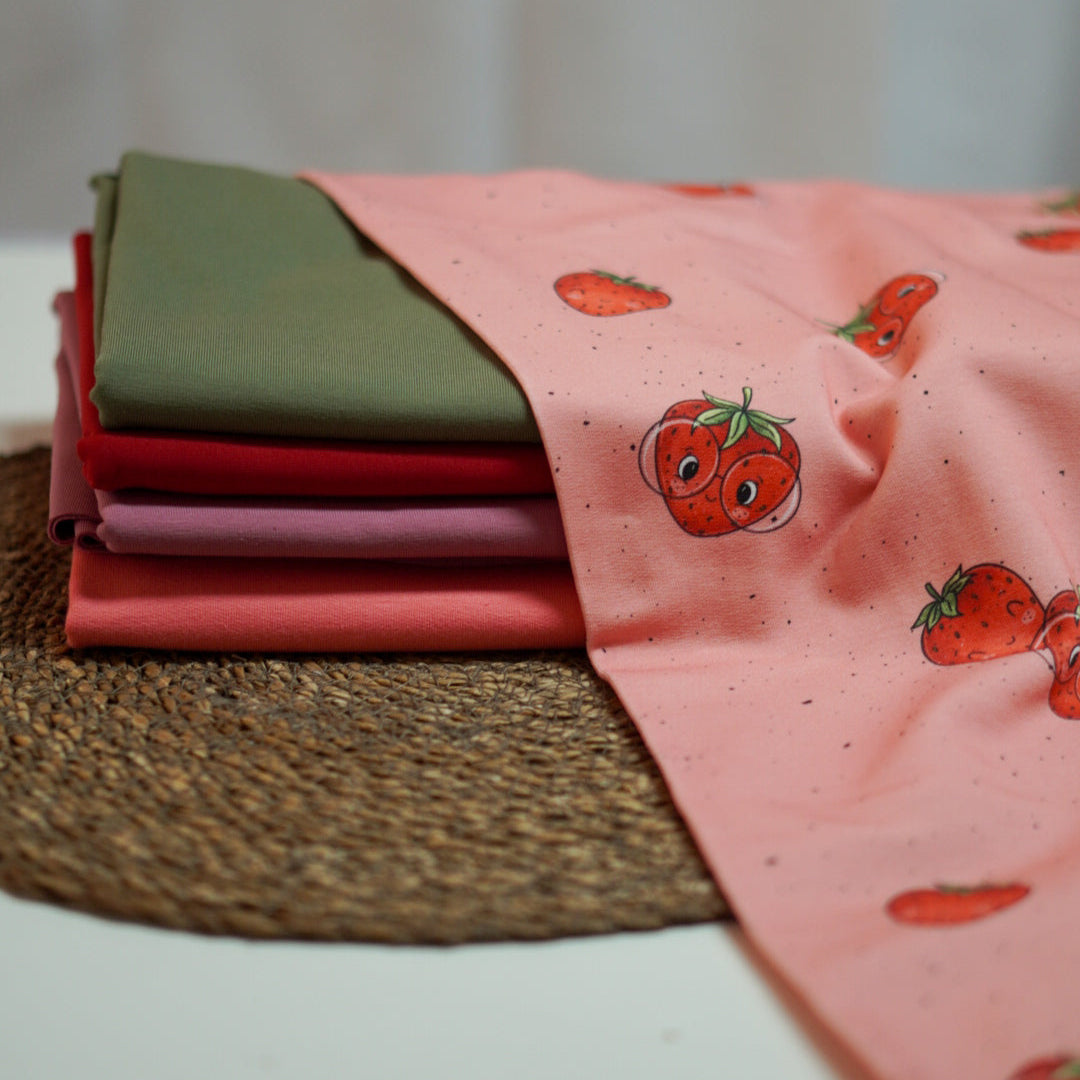 Kinderstoff Meterware süße Erdbeeren Früchte mit Gesicht und Brille von Katzengold Design auf rosa