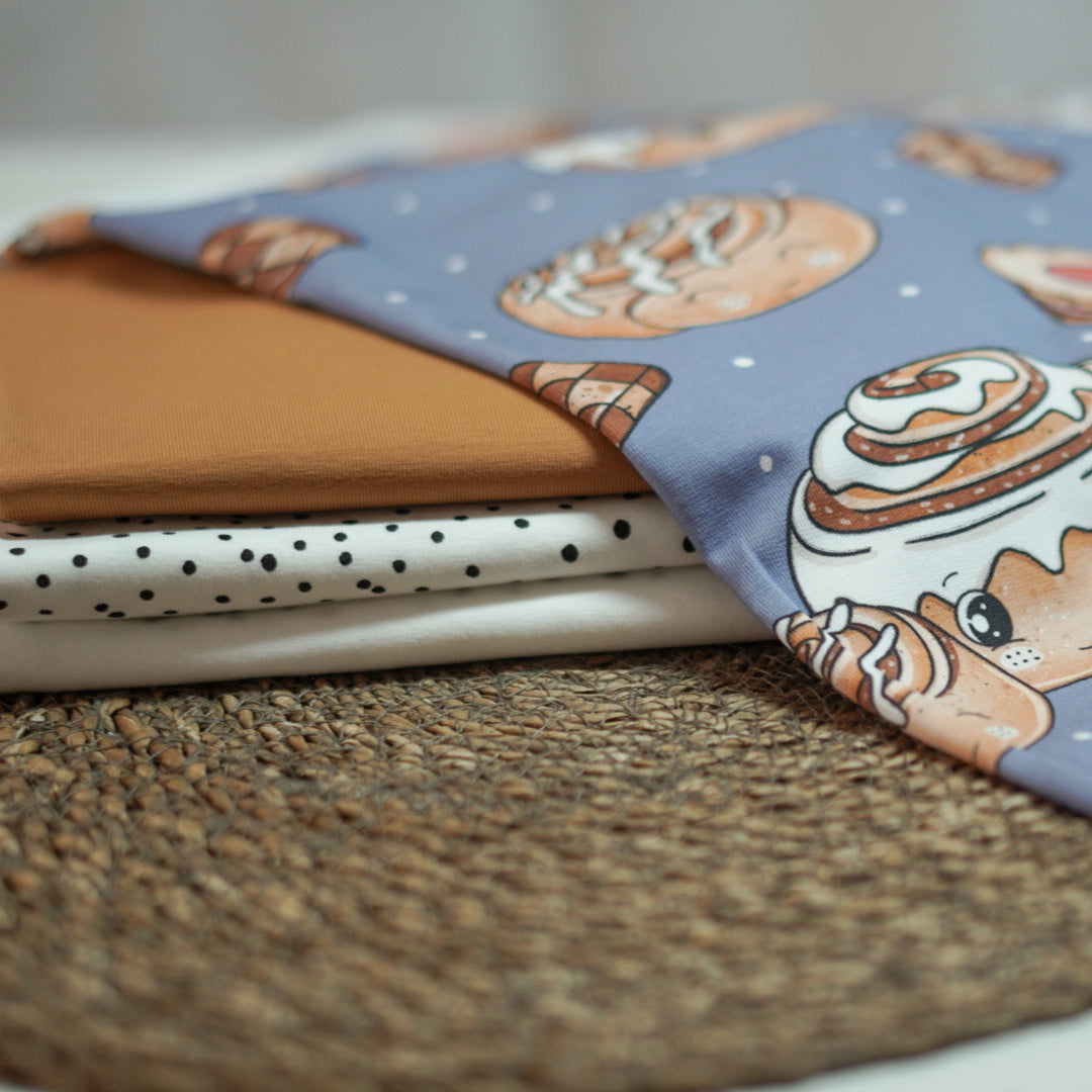 Kinderstoff mit weihnachtlichen Gebäck, wie Zimtschnecken und Plätzchen auf blau von Katzengold Design